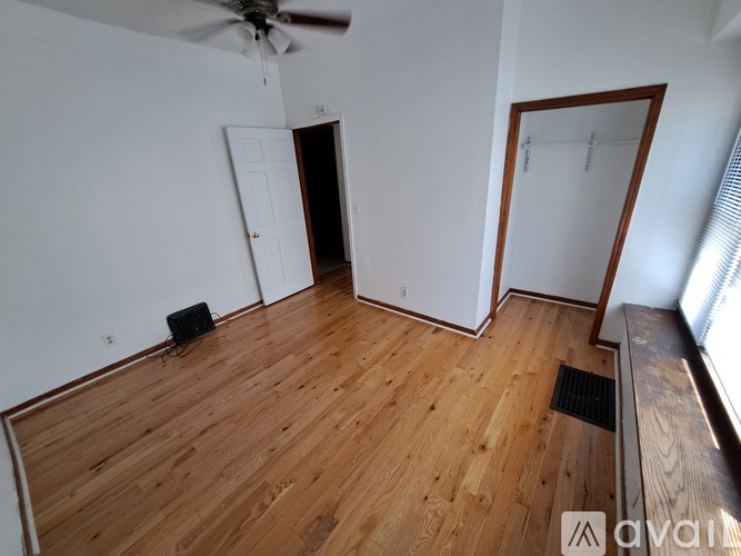 A room with wooden flooring and a ceiling fan.