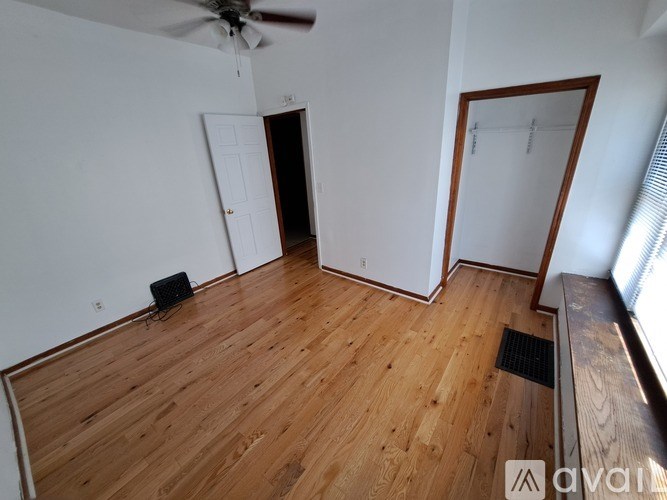 A room with wooden flooring and a ceiling fan.