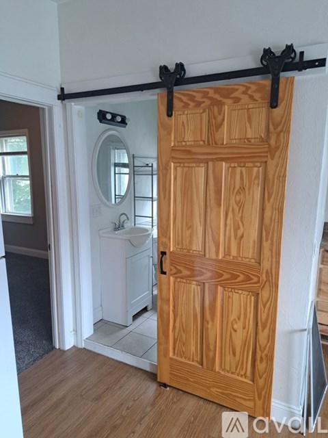 A wooden door with a black bar at the top is closed.