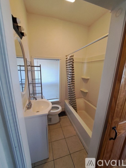 A bathroom with a toilet, sink, and bathtub.