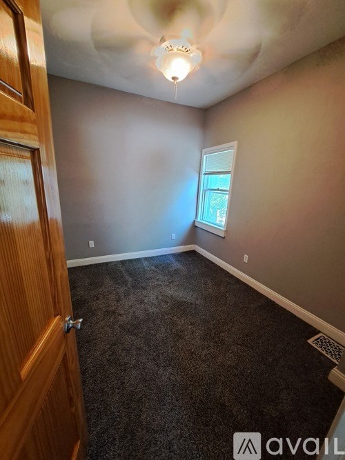 A room with a carpeted floor and a ceiling light.