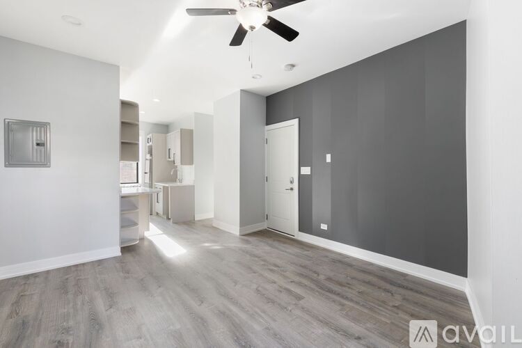 A spacious room with a ceiling fan and lighting fixtures.