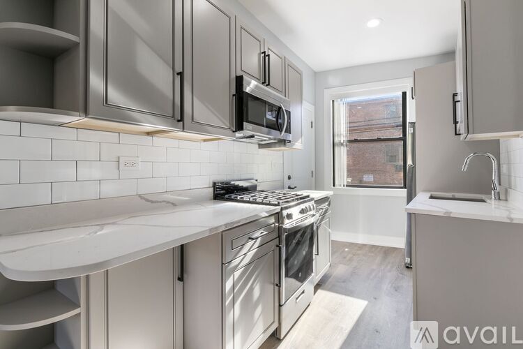 A modern kitchen with stainless steel appliances and white countertops.