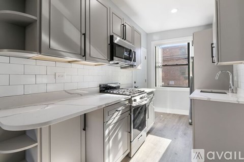 A modern kitchen with stainless steel appliances and white countertops.
