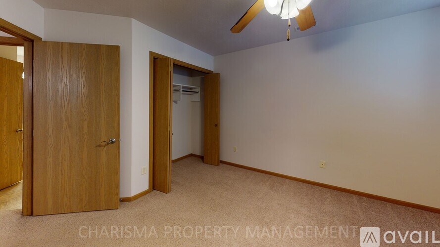 A room with a ceiling fan and two doors.