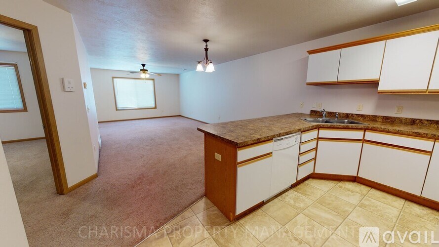 A kitchen with white cabinets and a brown countertop is available for rent.