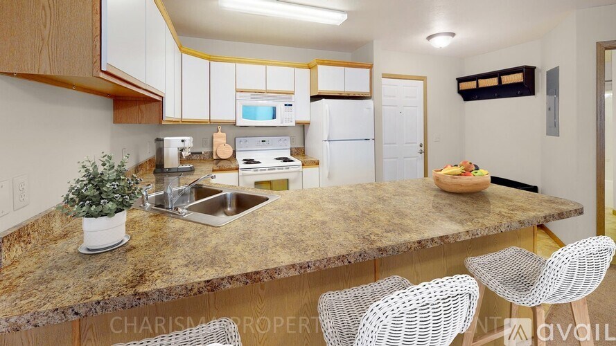 A kitchen with a granite countertop and white cabinets.