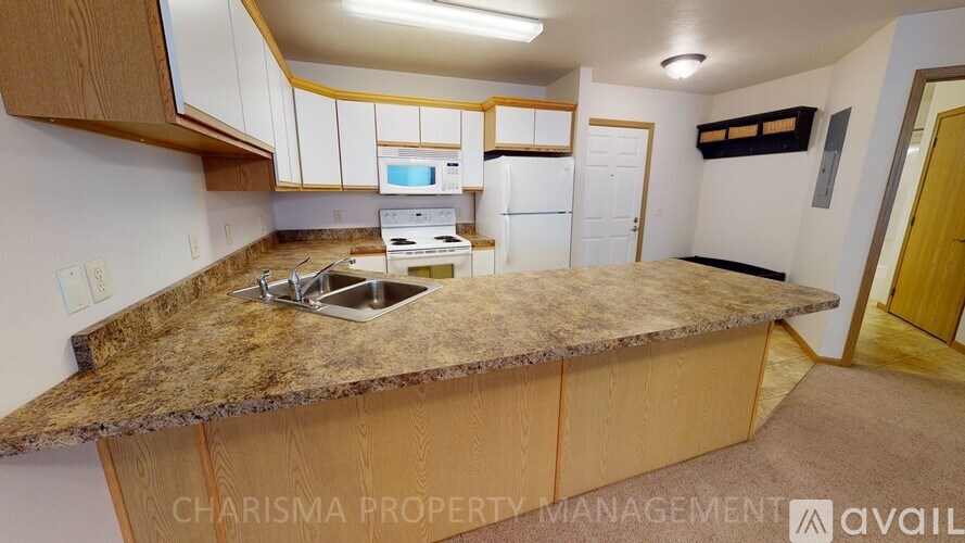 A kitchen with a granite countertop and wooden cabinets.