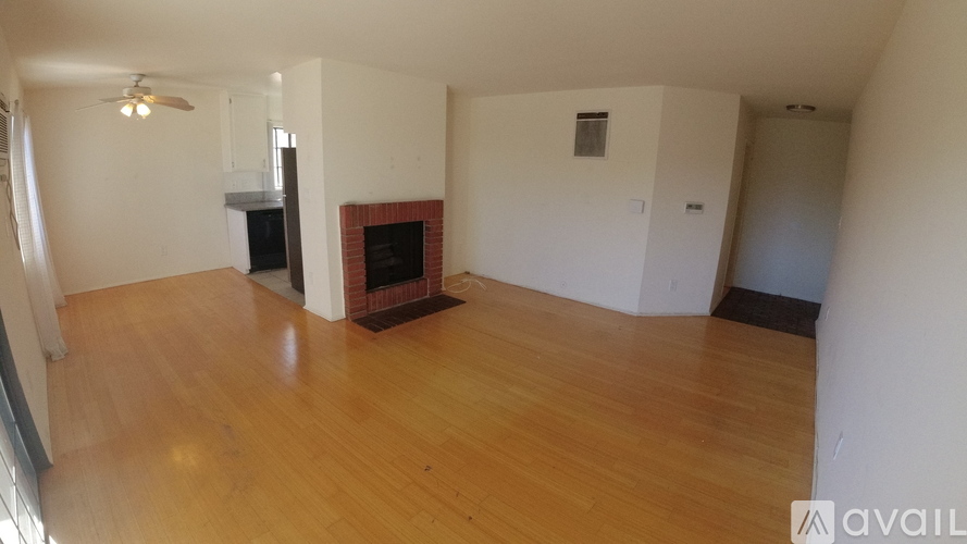 A living room with a fireplace and wooden floors.