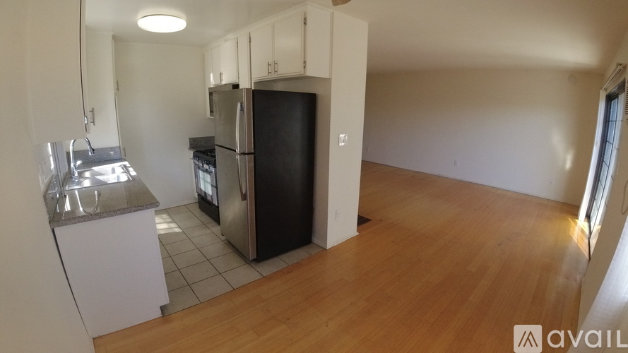 A room with wooden flooring and white walls.