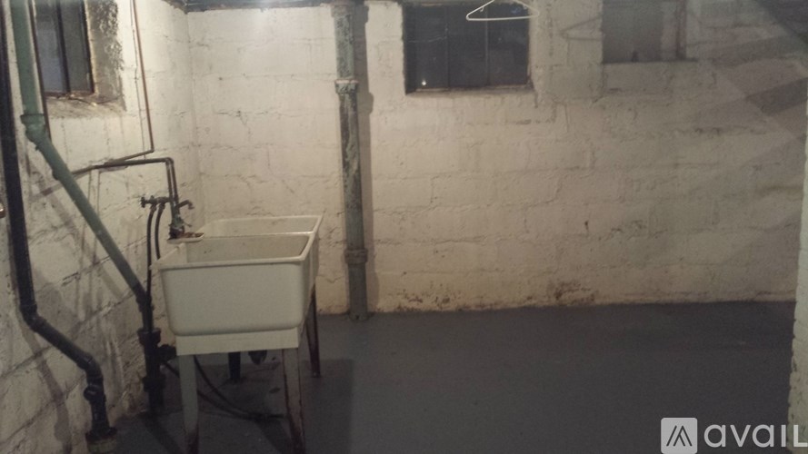 A white chair is in front of a sink in a dirty room.