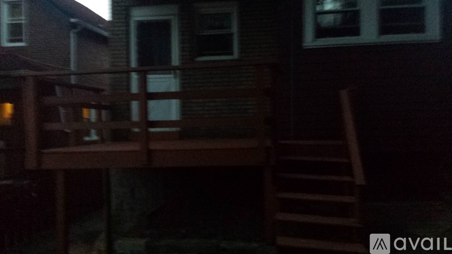 A wooden deck with a staircase leading to a house.