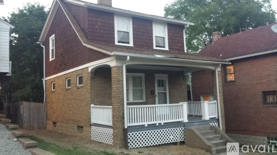 A red brick house with a white porch.
