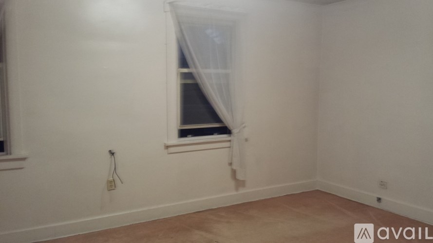 A room with a window and a white wall.