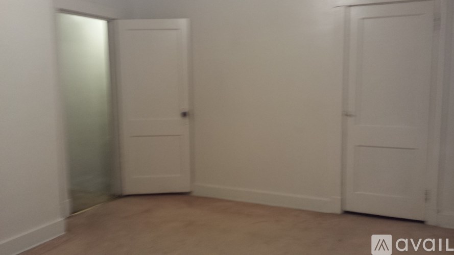 A room with two doors and a wall with a logo on it.