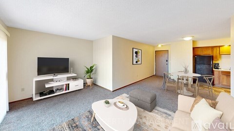 A living room with a white coffee table and a television on a white stand.