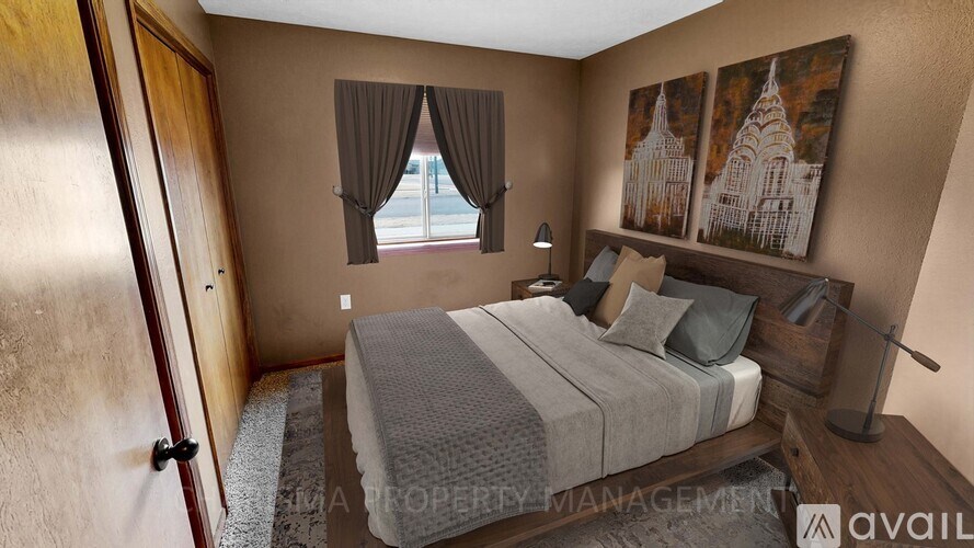 A bedroom with a large bed and a window with curtains.