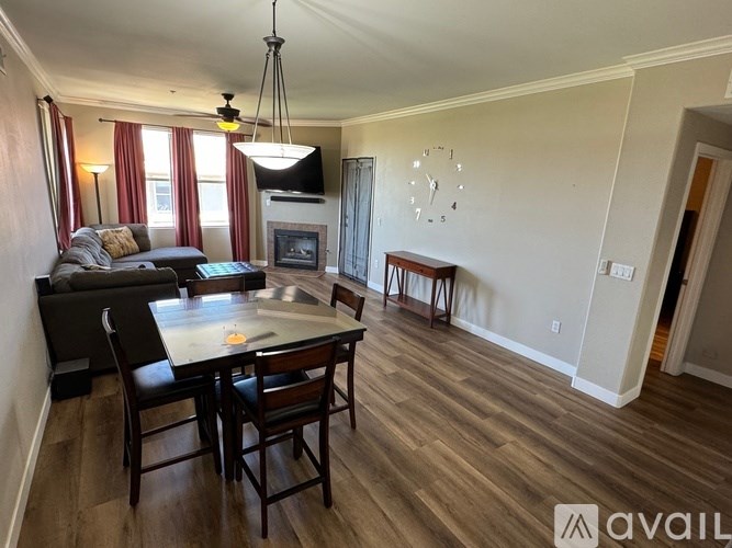 A living room with a fireplace and a large clock on the wall.