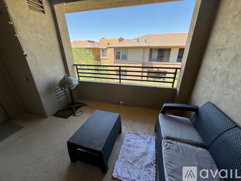 A living room with a grey sofa and a black ottoman.