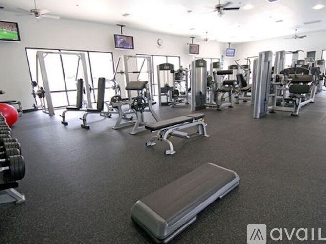 A gym with a variety of equipment including weights and benches.