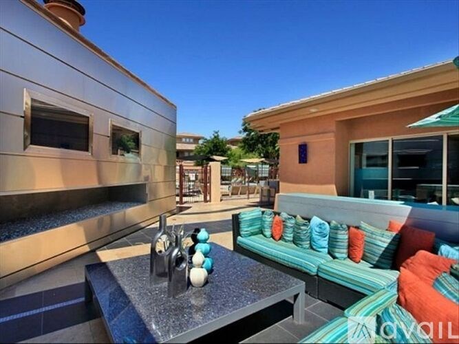A modern outdoor seating area with a bar and colorful cushions.