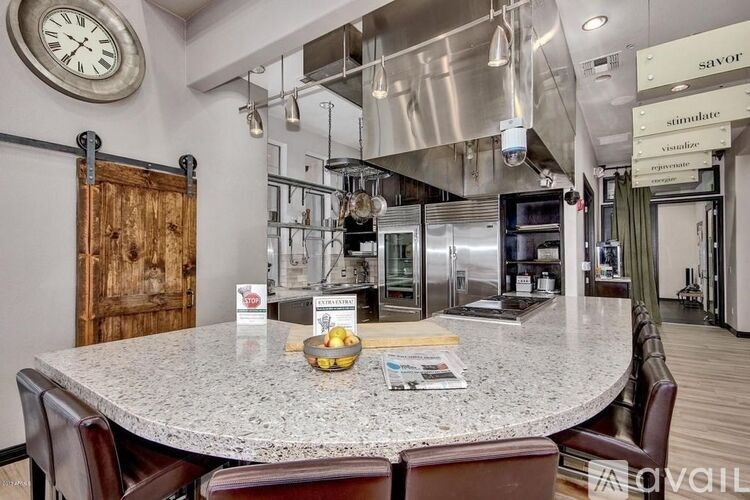A modern kitchen with a large island and a clock on the wall.