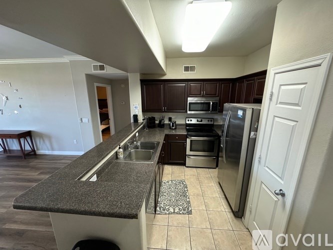 A kitchen with a refrigerator, oven, and microwave.