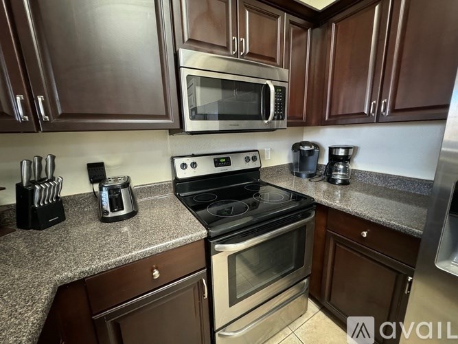 A kitchen with a granite countertop and stainless steel appliances.