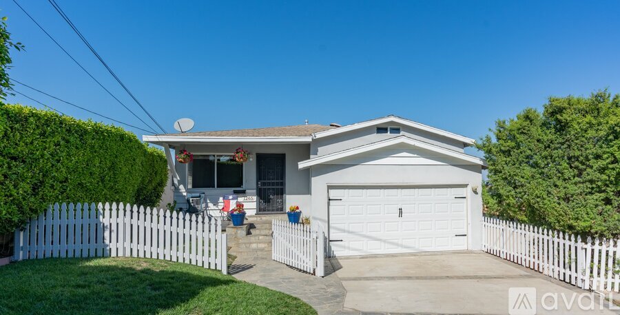 A house with a white fence and a garage door.