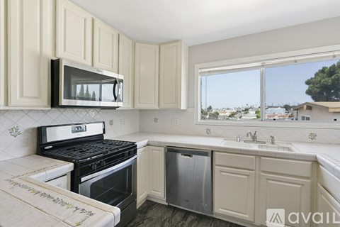 A kitchen with a black stove and white cabinets.