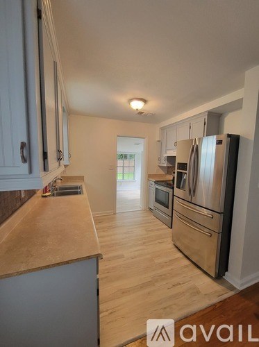 A kitchen with wooden floors and stainless steel appliances.