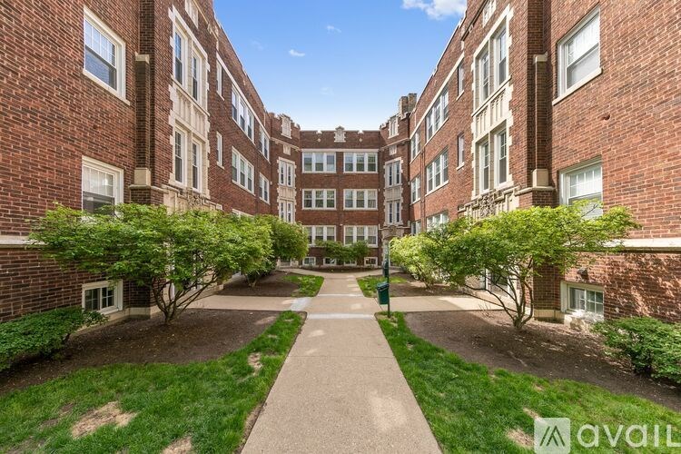 A courtyard surrounded by red brick buildings with a walkway in the middle.