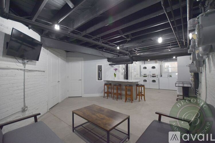 A large open room with a wooden table and a television on the wall.