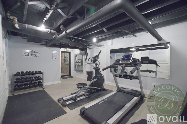 A gym with a treadmill, weights, and exercise equipment.