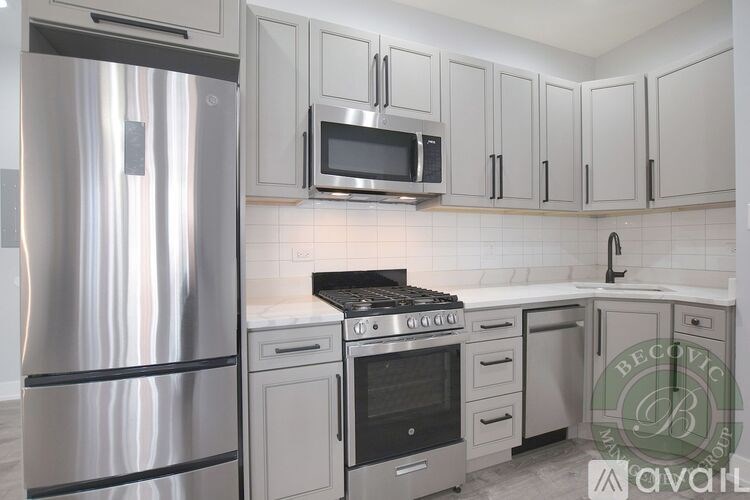 A kitchen with a stainless steel refrigerator and white cabinets.