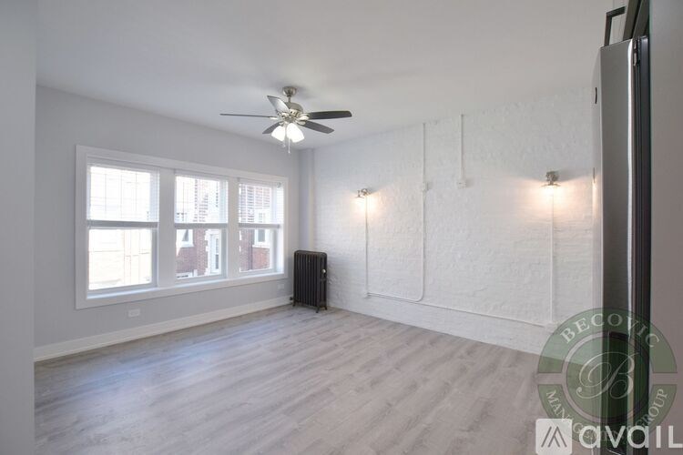 A spacious room with a ceiling fan and a radiator on the wall.