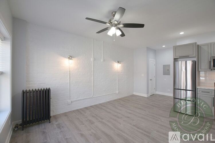 A spacious room with a ceiling fan and lighting fixtures.