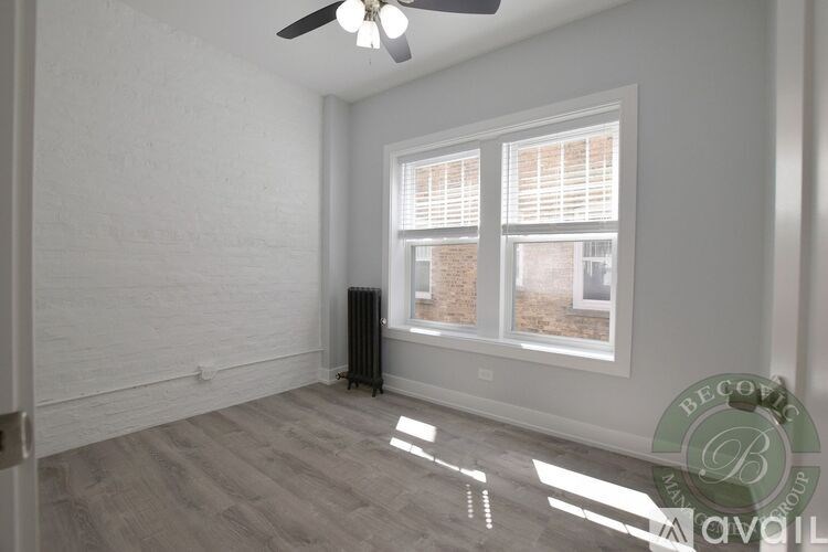 A room with a ceiling fan and a window with blinds.