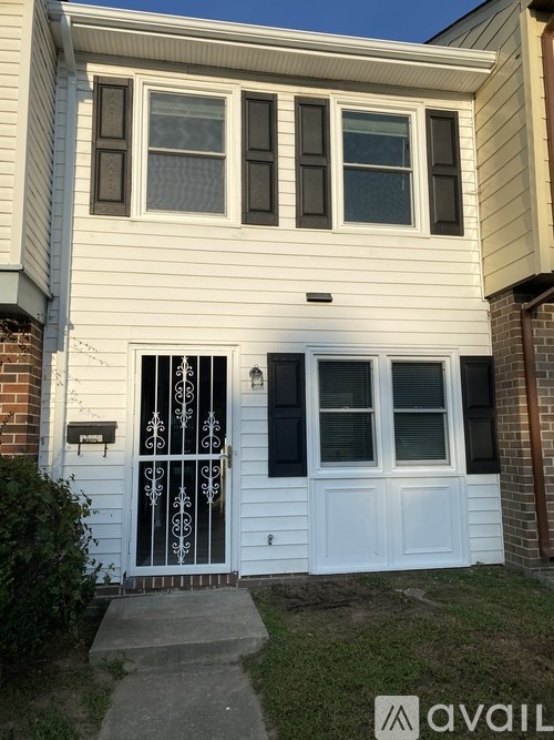 A white house with a black door and windows.