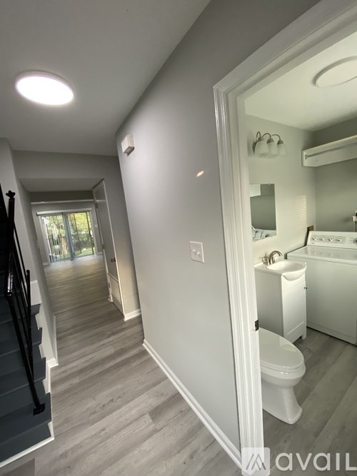 A bathroom with a toilet, sink, and mirror.