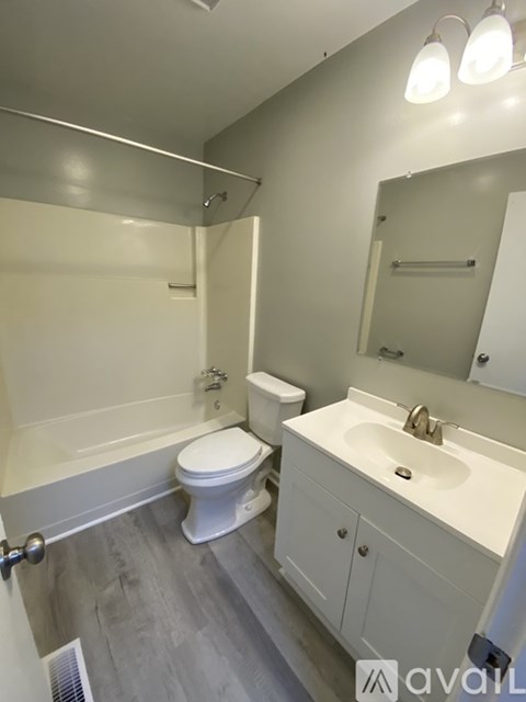 A white toilet sits next to a bathtub in a bathroom.