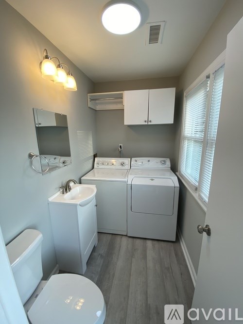 A bathroom with a toilet, sink, and mirror.