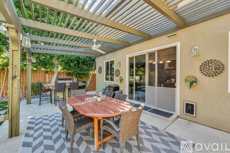 A patio with a table and chairs under a roof.