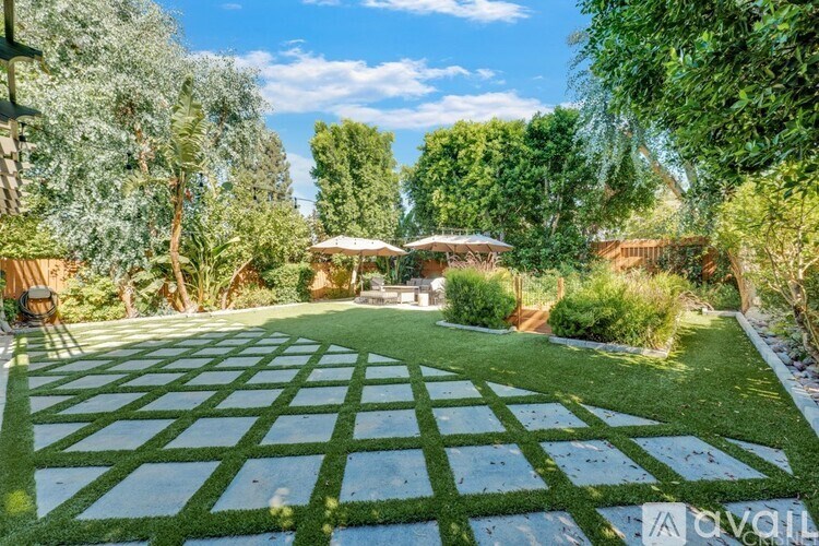 A backyard with a green lawn and a wooden fence.