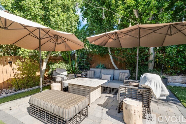 A patio with a table and chairs under umbrellas.