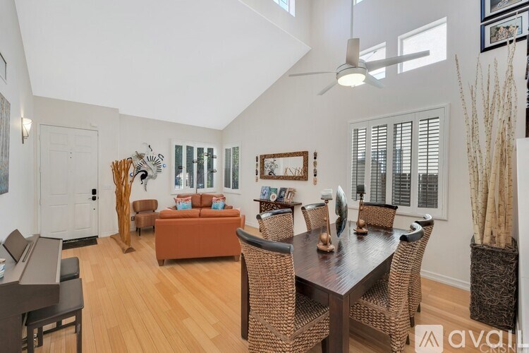 A living room with a brown sofa and a wooden dining table.