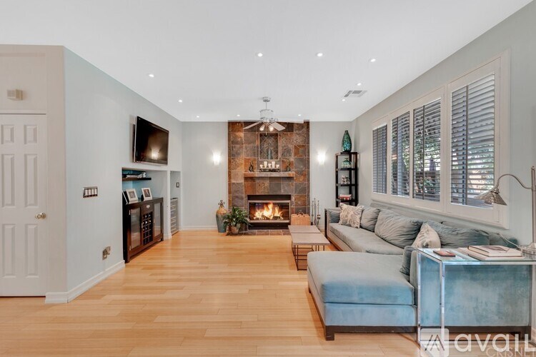 A modern living room with a fireplace and a blue couch.