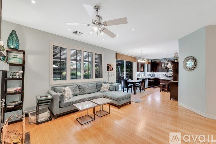 A living room with a grey couch and a glass coffee table.