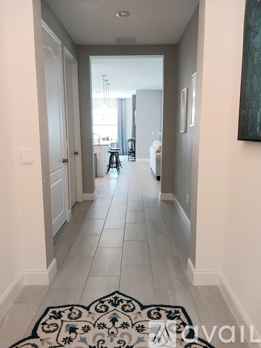 A hallway with a black and white patterned rug on the floor.