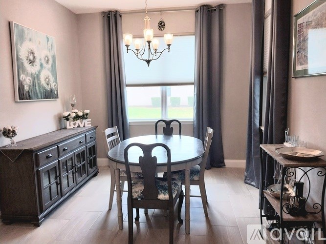 A dining room with a table set for four.